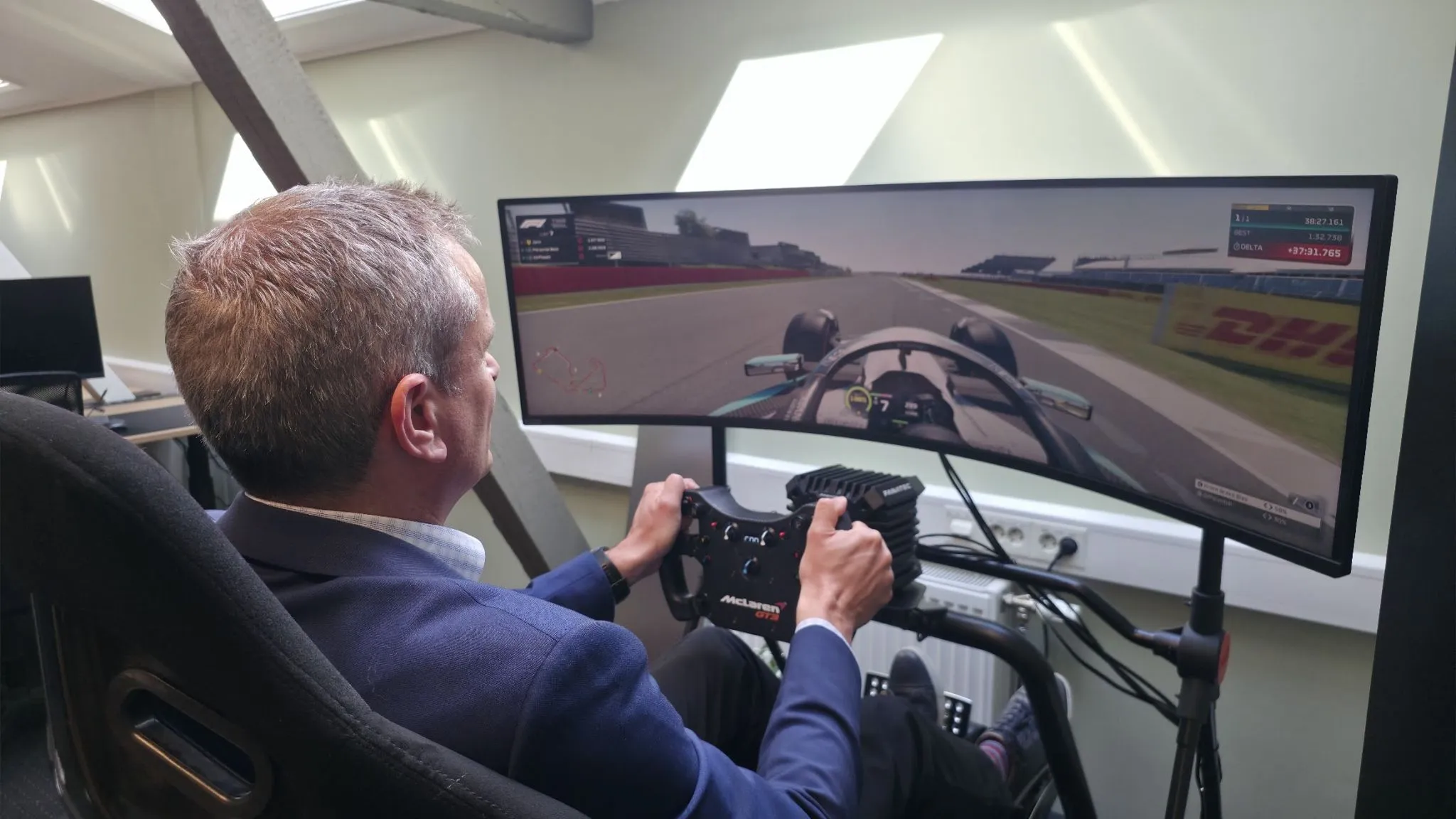 Guy March in the FM racing simulator, McLaren wheel, Silverstone on screen
