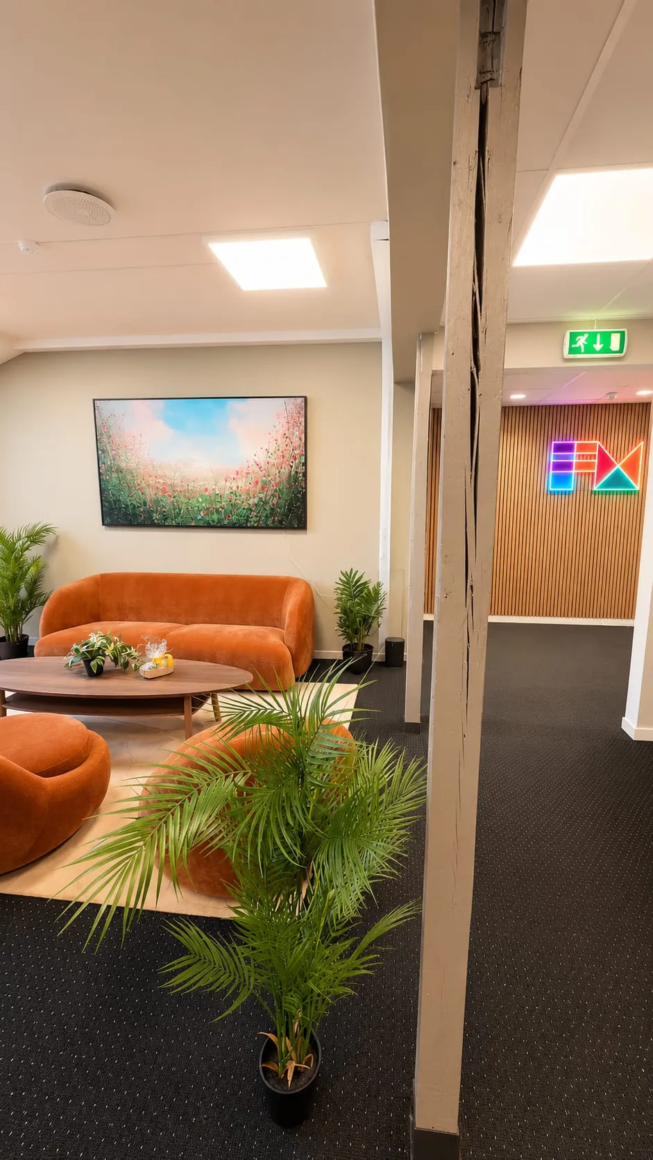 The lounge on the fourth floor, with the FM CyberSecurity logo in neon on the wall behind