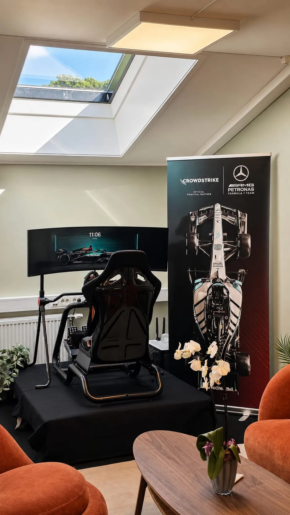 Racingsimulatoren på kontoret, foran en CrowdStrike og Mercedes-AMG Petronas F1-rollup